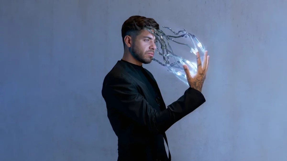 Anyma facing a glowing robotic hand